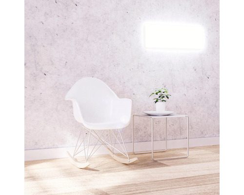 Scène avec rocking-chair, table d''appoint et plante devant une applique murale