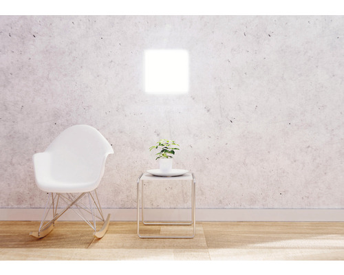 Pièce lumineuse avec fauteuil à bascule blanc, table d''appoint et plante d''intérieur