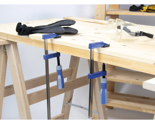 Werkbank mit Schraubzwingen, Arbeitshandschuhen und Schutzbrille