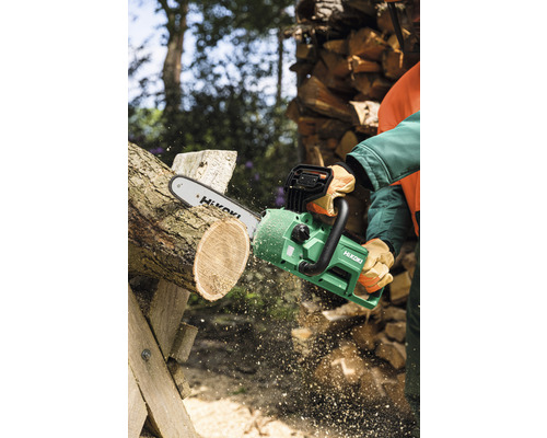 Person sägt Holz mit einer grünen Elektrokettensäge von Hikoki.
