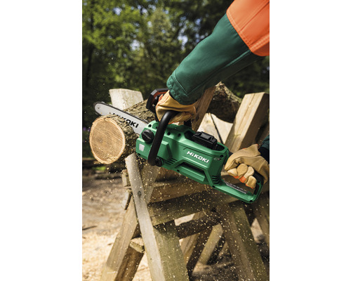 Eine Person sägt mit einer grünen HiKoki Akku-Kettensäge Holz.