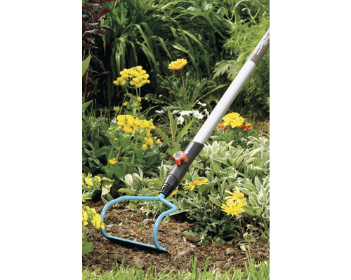 Outil de jardinage pour travailler le sol dans un jardin fleuri