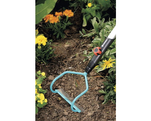 Outil de jardinage en utilisation dans une plate-bande