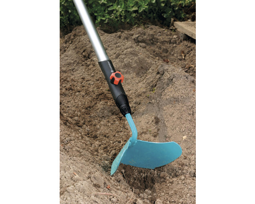 Sarcloir avec manche utilisé dans le sol du jardin.