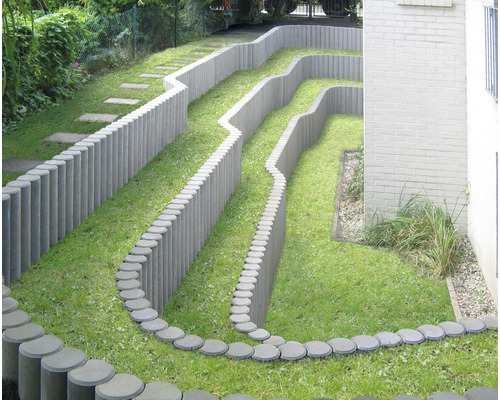 Terrassierter Garten mit Rasen und Beetbegrenzung aus Betonpalisaden