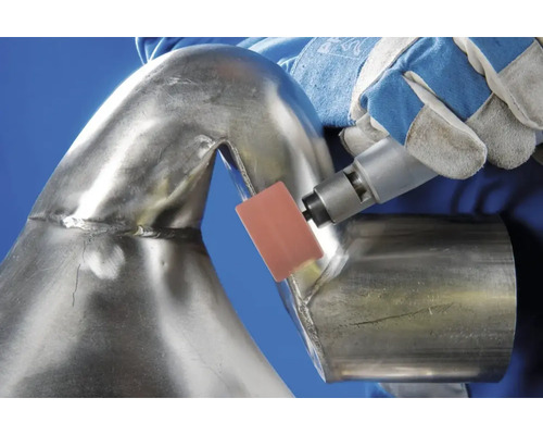 Eine Person schleift mit einem Schleifwerkzeug ein Metallrohr.