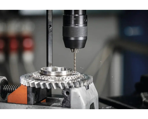 Usinage du métal avec perceuse sur roue dentée