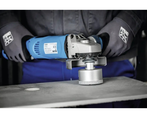 Bediener bohrt mit einer Diamantbohrkrone ein Loch in eine Betonplatte mit einem Winkelschleifer