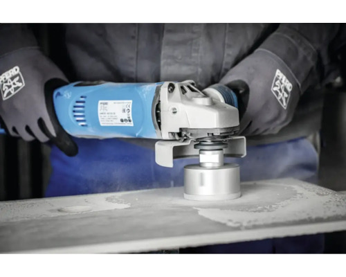 Eine Person benutzt einen Winkelschleifer mit Bohrkrone an einer Platte.