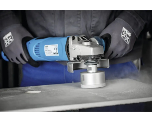 Person verwendet einen Trennschleifer mit Diamantbohrkrone zum Bohren eines Lochs in eine Oberfläche. PFERD Logo auf Handschuhen.