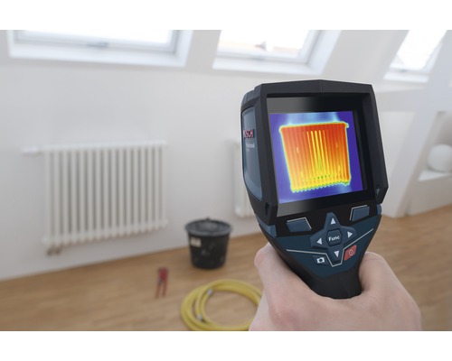 Main tenant une caméra thermique Bosch devant un radiateur