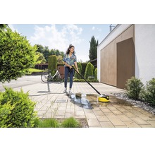 Femme nettoie la terrasse avec un nettoyeur de terrasse et un nettoyeur haute pression