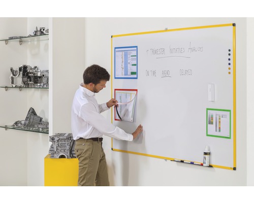 Un homme interagit avec un tableau blanc d''organisation avec des cadres de documents magnétiques pour le bureau