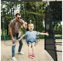 Un père pousse son enfant sur une balançoire d''une tour de jeu.