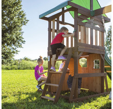 Spielplatz mit Holzhaus, Leiter und Rutsche im Garten mit spielenden Kindern
