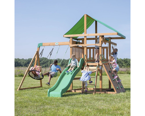 Aire de jeux pour enfants avec balançoires, toboggan et mur d''escalade dans le jardin.