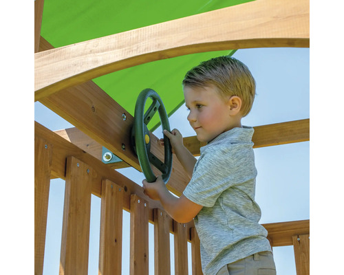 Garçon jouant avec un volant sur une tour de jeux en bois