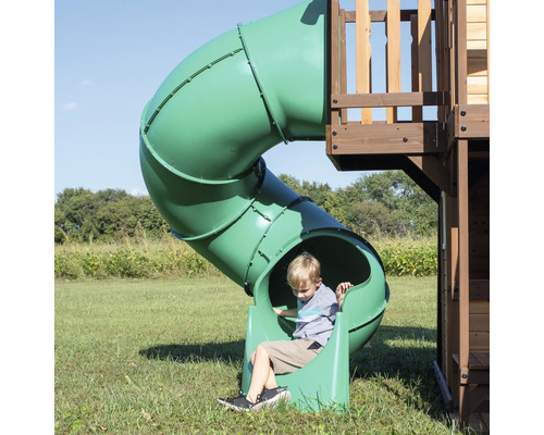 Junge auf einer grünen Röhrenrutsche auf einem Spielplatz