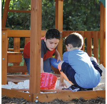 Zwei Kinder spielen im Sandkasten eines Spielturms.