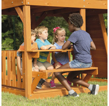 Kinder spielen auf einem Holzspielplatz mit Picknicktisch.
