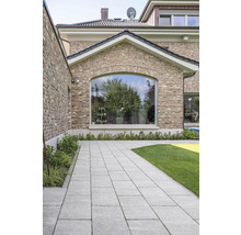 Gepflasterter Weg im Garten mit Rasenfläche