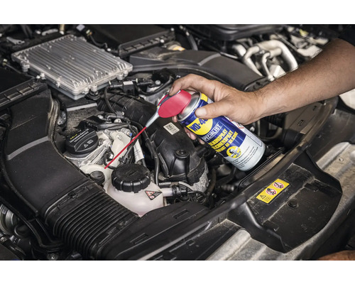 Anwendung von Silikonspray von WD-40 im Motorraum eines Autos
