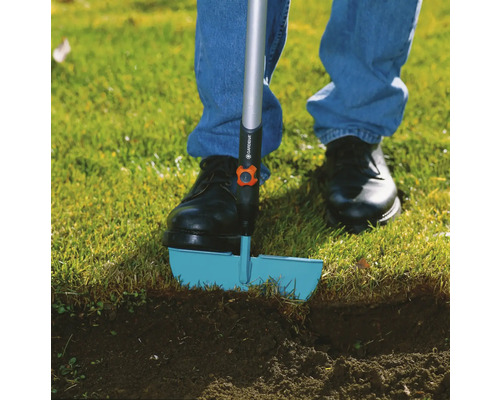 Une personne utilise un coupe-bordure dans le jardin.