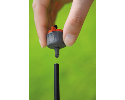 Système d''irrigation goutte à goutte avec main sur fond vert
