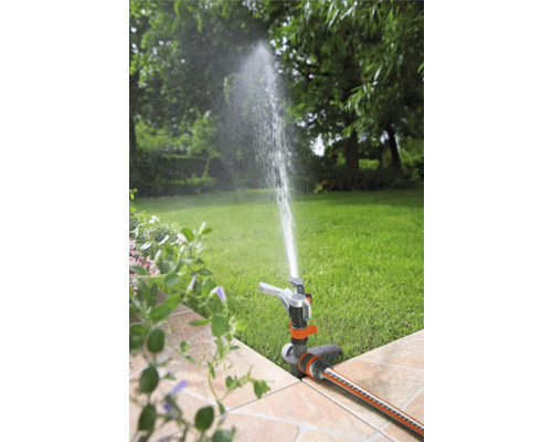 Scène de jardin avec arroseur de pelouse arrosant la pelouse