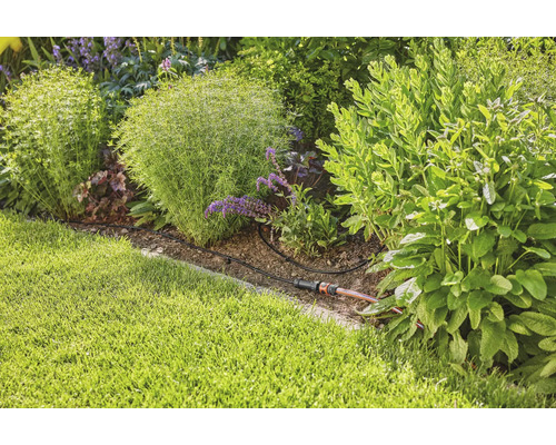 Système d''arrosage de jardin dans un parterre de jardin planté.