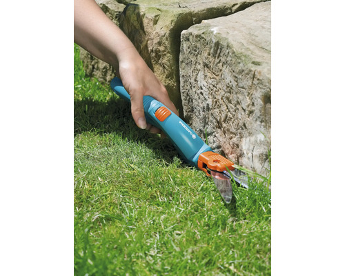 Cisailles de jardin utilisées pour couper les bordures de pelouse près d''une pierre