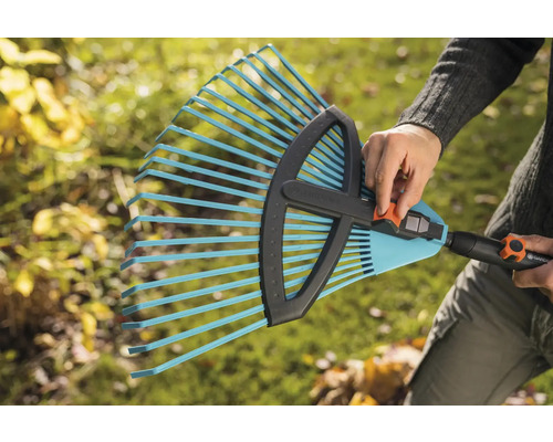 Une personne tient un râteau réglable de Gardena