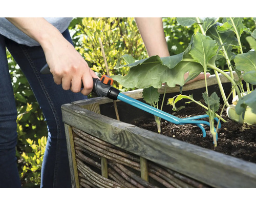Jardinage avec une griffe de jardin dans un potager surélevé