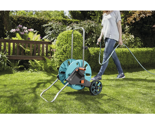 Gardena Schlauchwagen im Garten mit Frau beim Bewässern