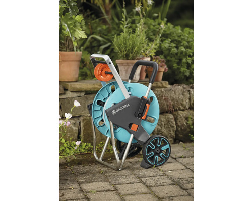 Gardena Schlauchwagen mit Garten und Pflanzen im Hintergrund