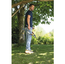 Ein Mann steht im Garten und hält eine Astschere.