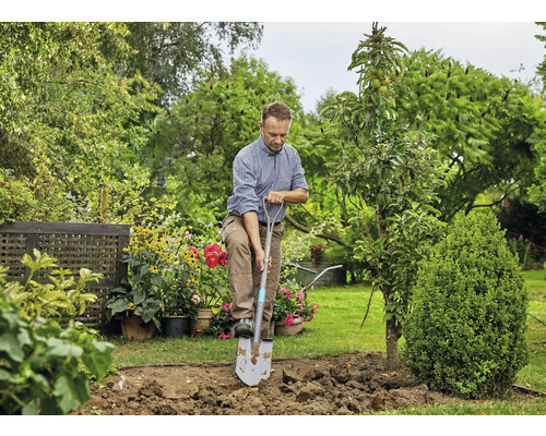 Homme bêchant avec une bêche dans le jardin