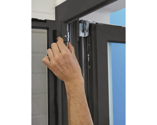 Hand montiert einen Fensterbeschlag an einem Fensterrahmen