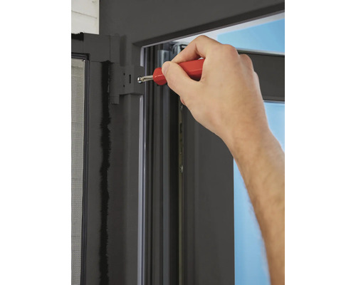 Montage eines Insektenschutzgitters mit einem Schraubendreher an einem Fensterrahmen.