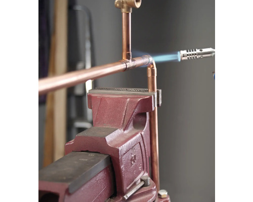 Tuyau de cuivre raccordé à l''aide d''un fer à souder et d''un établi