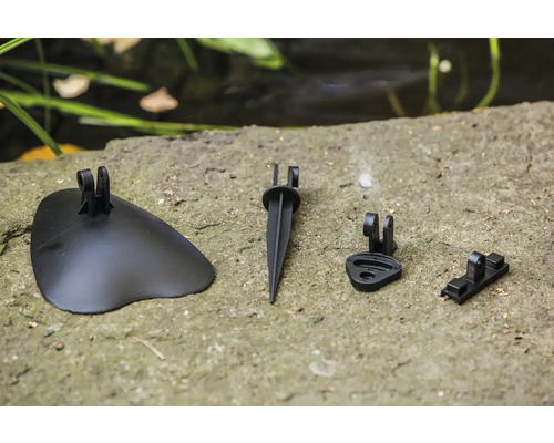 Verschiedene Zubehörteile für Gartenbeleuchtung auf einem Steinsockel