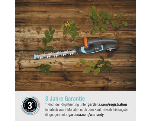 Gardena Akku-Heckenschere auf Holzhintergrund mit Blättern