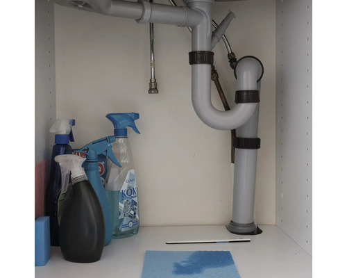 Siphon sous un lavabo avec des produits de nettoyage