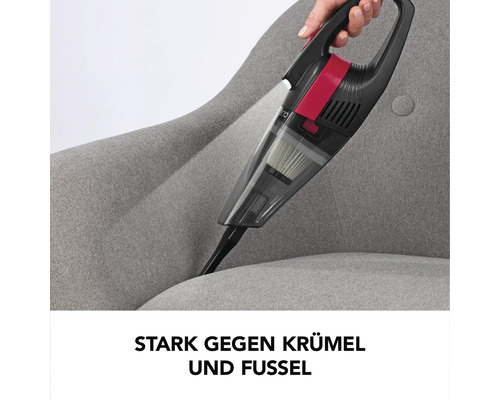 Akkusauger im Einsatz auf einem grauen Sessel