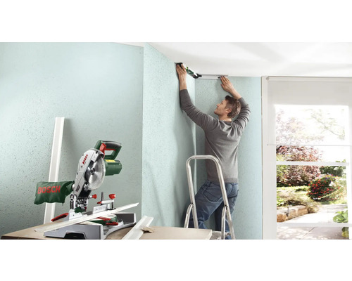 "Ein Mann montiert eine Deckenleiste mit einer Wasserwaage