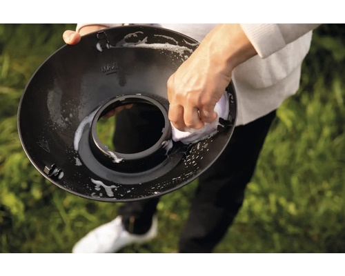 Reinigung einer schwarzen Lampenabdeckung mit einem Schwamm