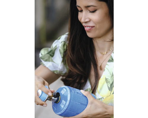 Frau schliesst Gaskartusche an Campingkocher an