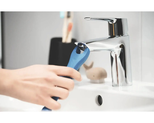 Person montiert einen Wasserhahn mit einem Spezialschlüssel im Badezimmer