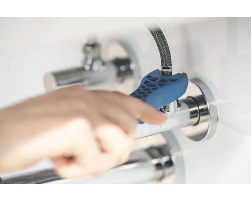 Eine Person benutzt einen Ventilschlüssel am Eckventil