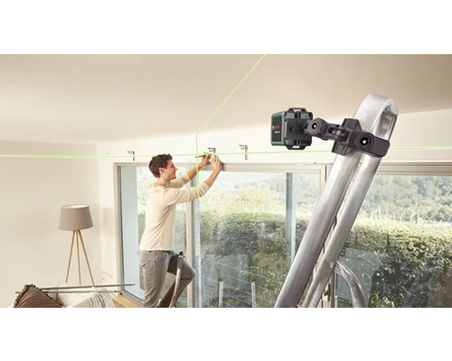 Un homme fixe un support au plafond à l''aide d''un laser linéaire et d''une échelle.